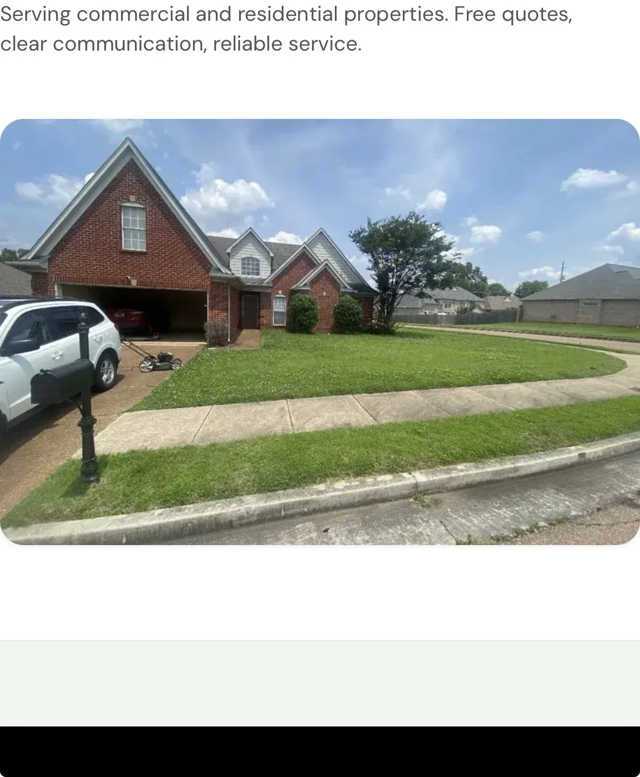 A well-maintained two-story brick home with a manicured lawn, tidy driveway, and open yard in a quiet suburban neighborhood.